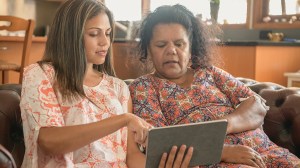 daughter helping mother with ombudsman on tablet