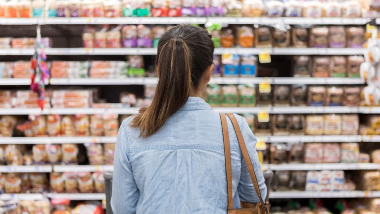 shopper_looking_at_shelves_full_of_products_in_a_supermarket