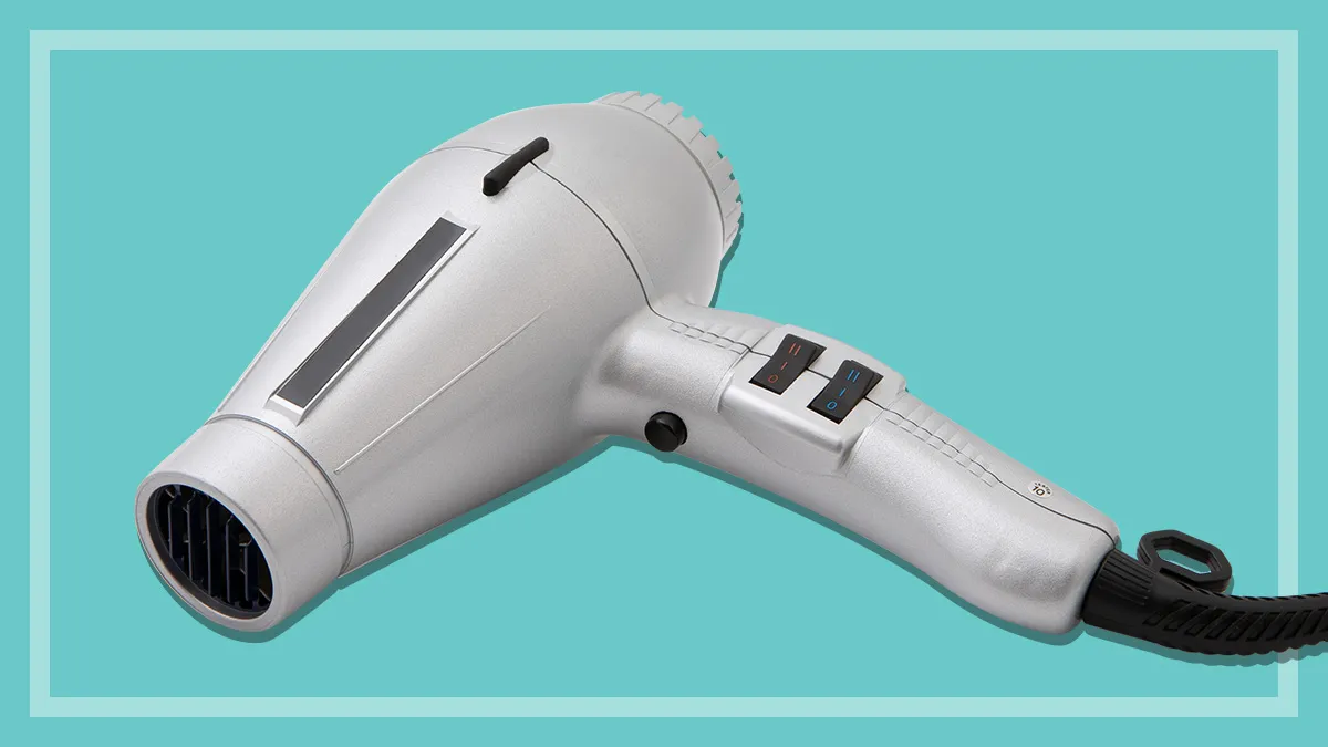 silver hair dryer on a teal background