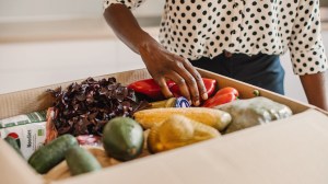 person taking ingredients out of a meal delivery kit