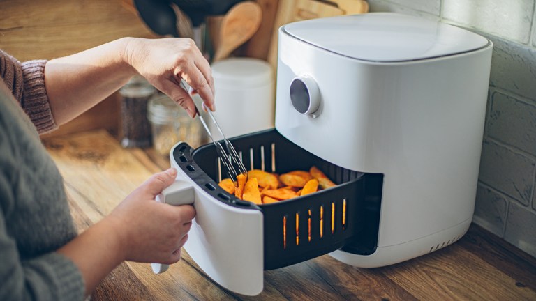 person_cooking_wedges_in_an_air_fryer