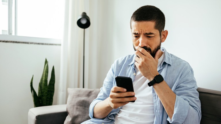 distraught person looking at smartphone