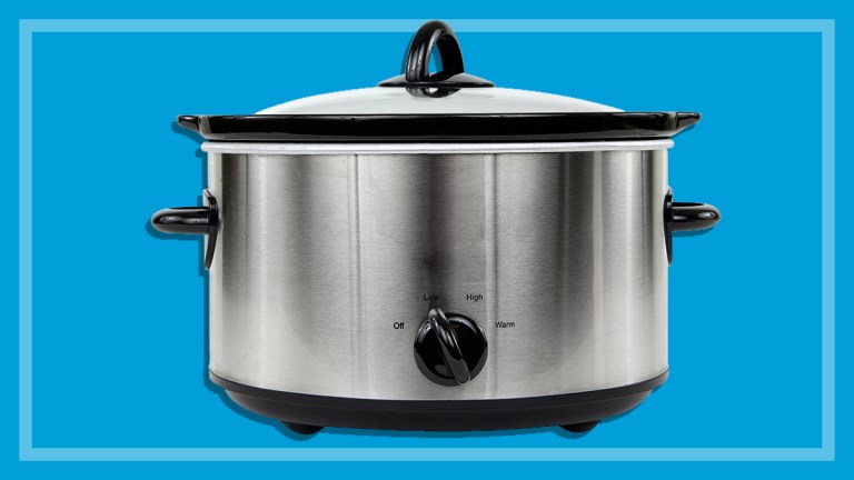 silver electric slow cooker on a blue backround