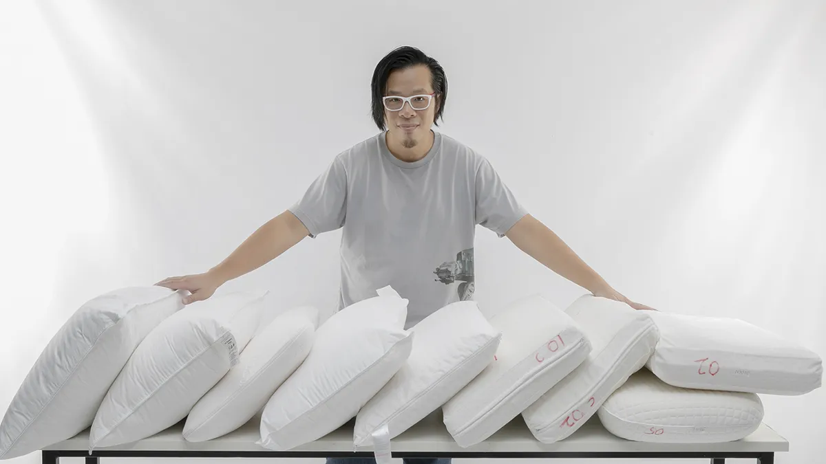 choice tester matthew tung standing behind a row of pillows