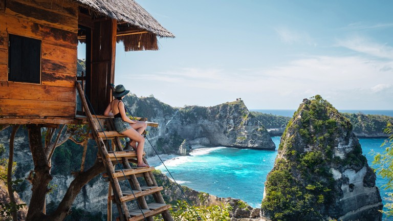person_on_steps_of_treehouse_at_diamond_beach_nusa_penida_island_in_bali_indonesia