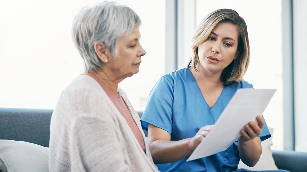 woman talking to nurse holding paperwork