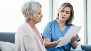 woman talking to nurse holding paperwork