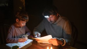 father and son at kitchen table in blackout no power