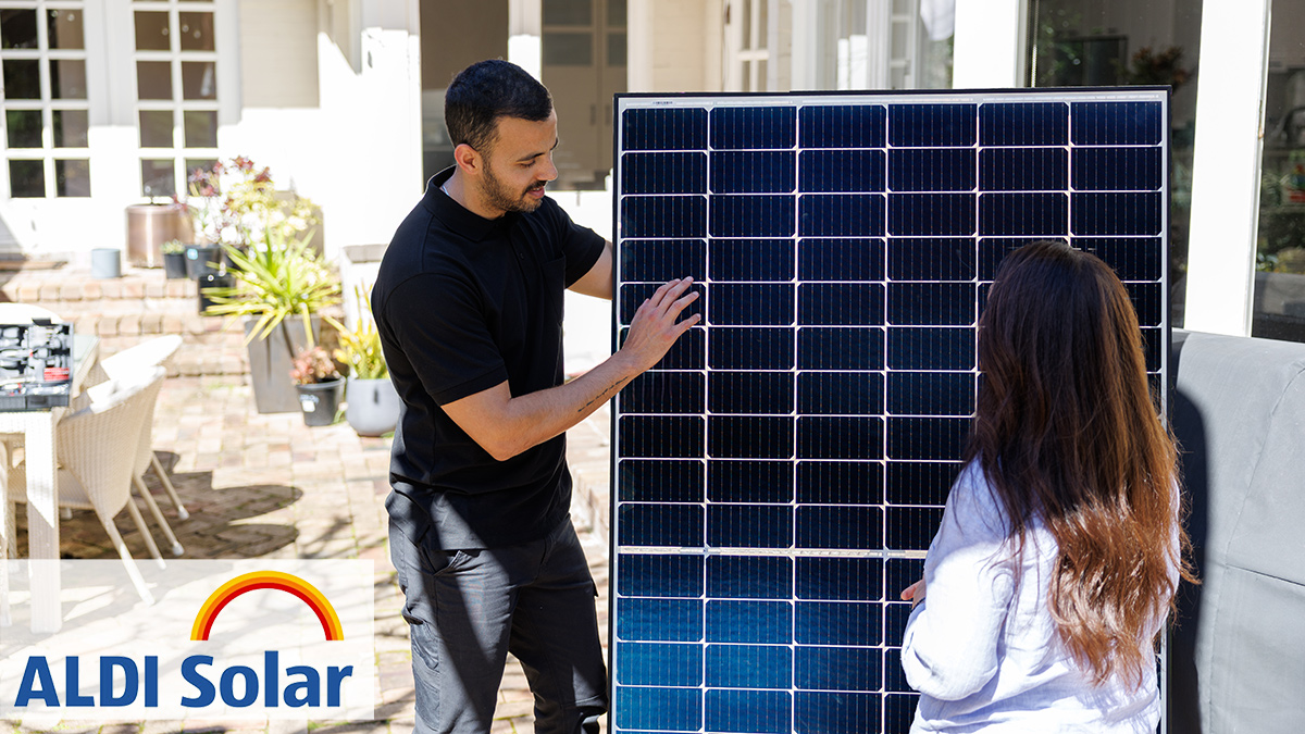 homeowner_with_aldi_installer_holding_a_solar panel and aldi solar logo