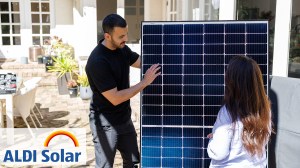 homeowner_with_aldi_installer_holding_a_solar panel and aldi solar logo