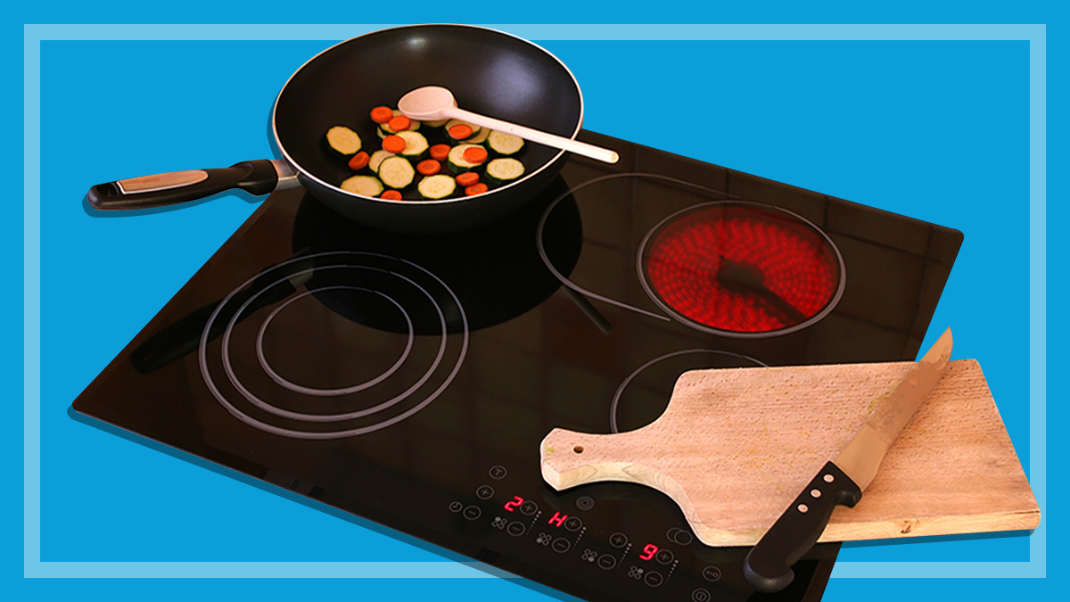 induction cooktop with a frypan and chopping board on a blue background