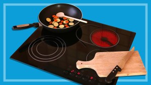 induction cooktop with a frypan and chopping board on a blue background