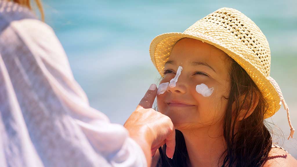 applying sunscreen to face