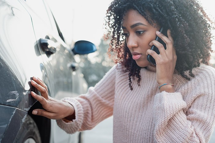 person looking and damage to their car