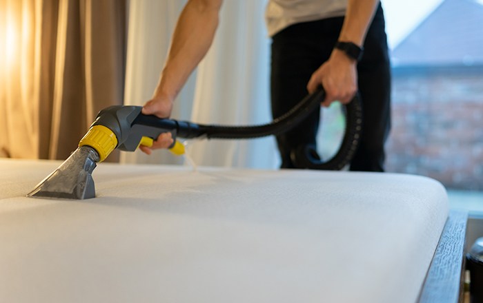 person vacuuming mattress
