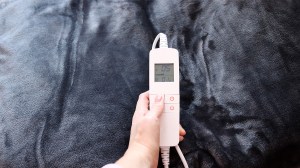 person adjusting controller of heated throw