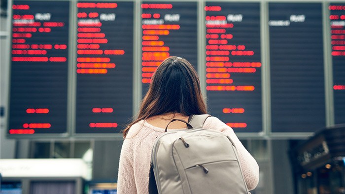 person_looking_at_departure_board_in_airport_terminal
