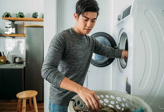 person_putting_clothes_into_a_dryer