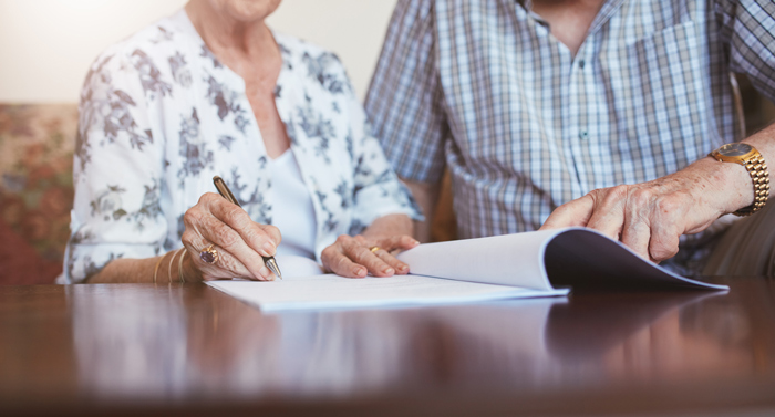 senior couple signing contract for retirment village