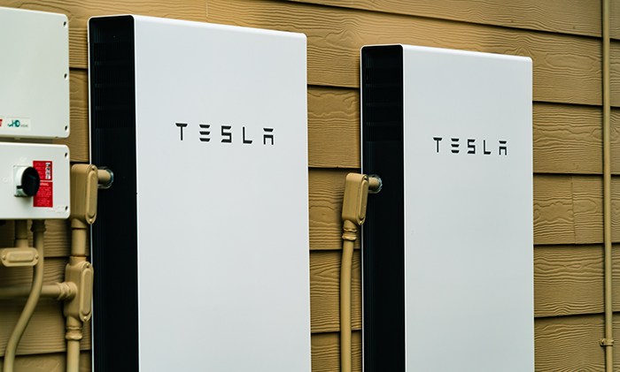 two_tesla_solar_batteries_on_outside_wall_of_a_home