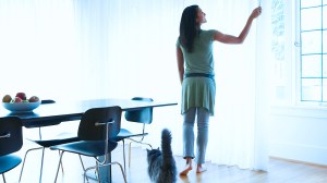 woman_closing_curtain_to_keep_home_cooler_in_summer