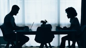 silhouette of couple at dining table and working on a laptop smsf