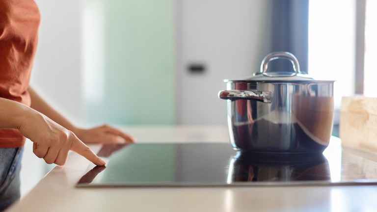 Person switching on an induction cooktop