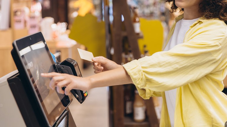Person scanning their loyalty card at a supermarket checkout