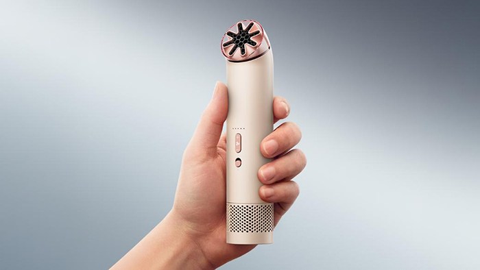 A hand holding the Dyson HushJet mini fan.