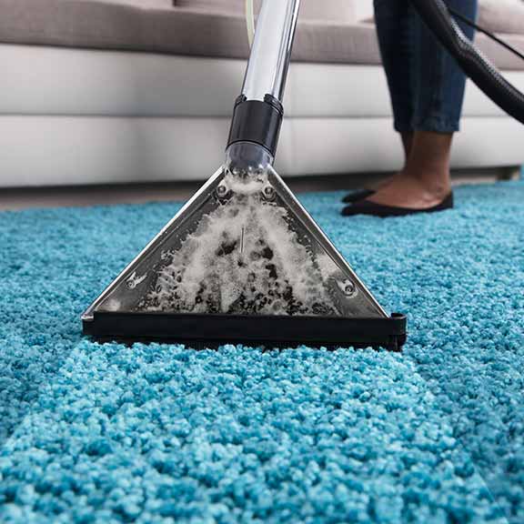 person using an at home carpet cleaner sq